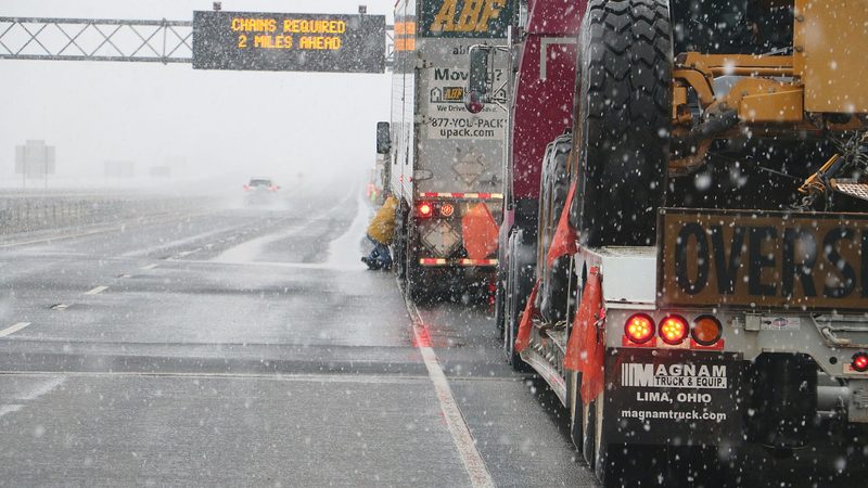 A roadside sign telling trucks that chains are required