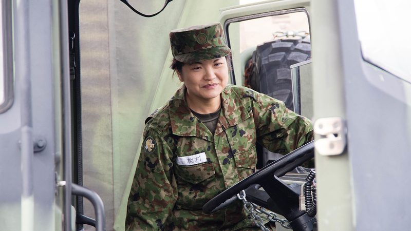 A person climbing into the driver's seat of a truck