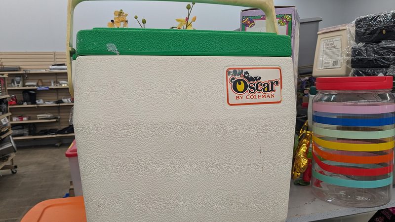 A Coleman cooler with the lid open, ice-chest food rather than a compressor fridge