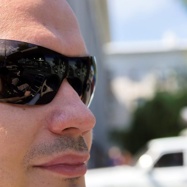 A driver wearing sunglasses in bright sun