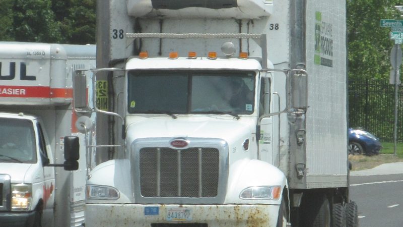 A Peterbilt pulling a refrigerated trailer, the cold-freight cousin of a cab fridge