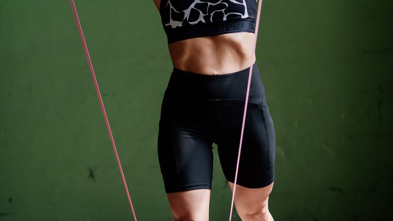 A woman exercising with a resistance band in a gym