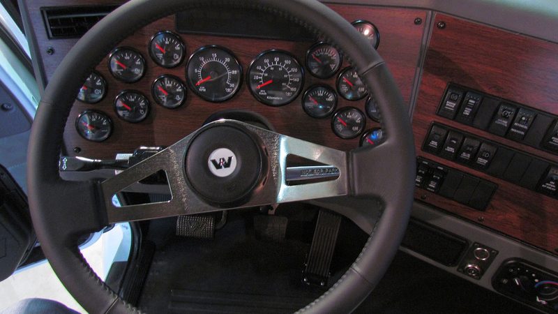 A steering wheel and dashboard in a truck cab